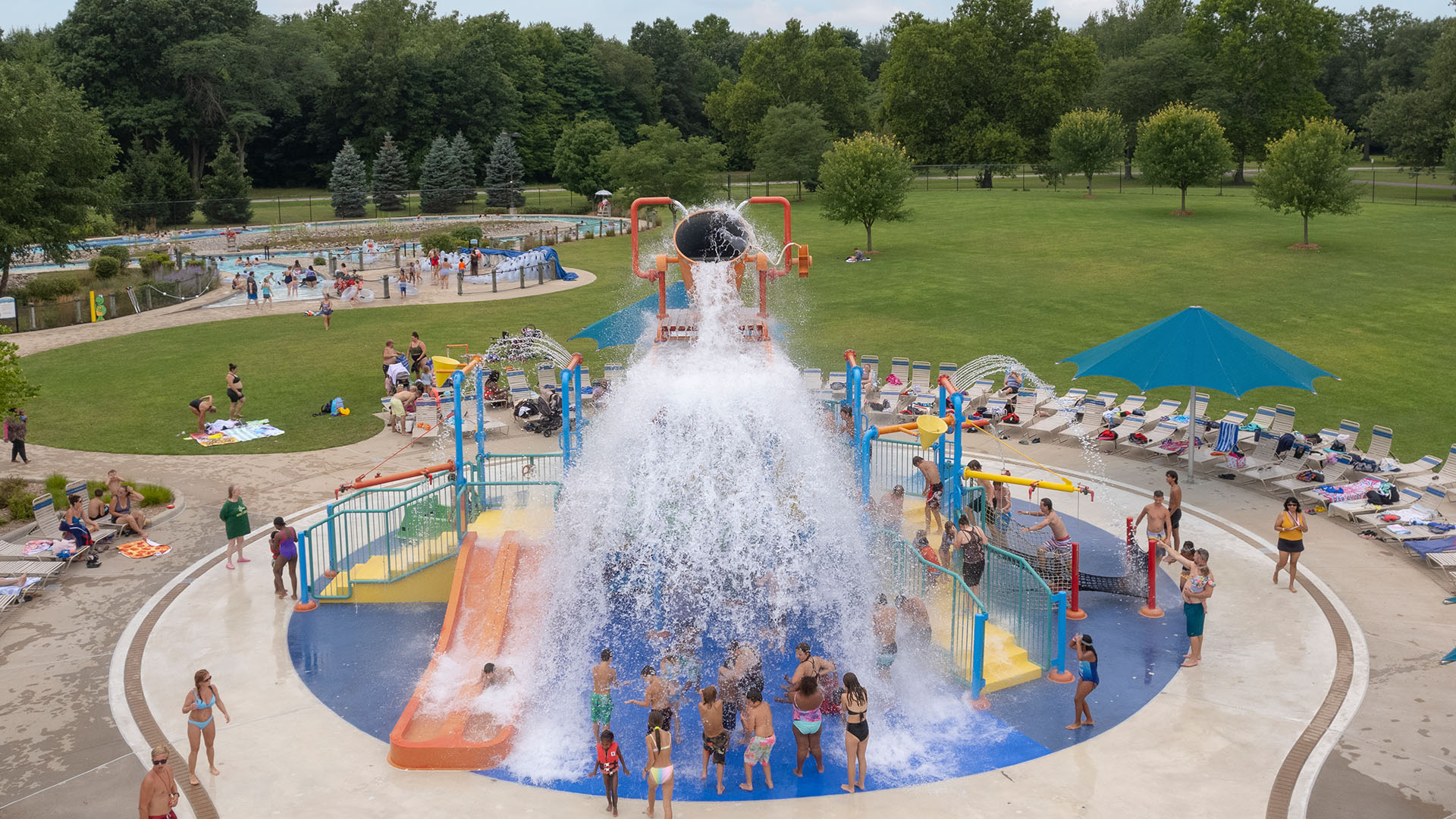Very colorful exciting splash pad surrounded by happy children